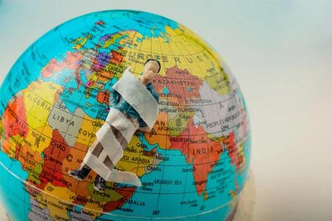 Tiny figurine of man model wrapped in bandages on earth 写真素材