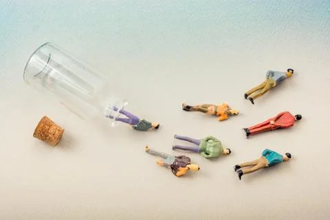 Tiny figurine of men miniature model coming out of bottle Foto stock