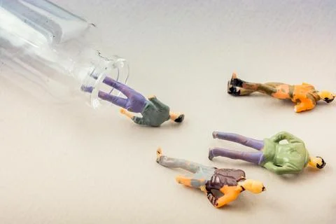 Tiny figurine of men miniature model coming out of bottle Foto stock