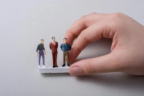 Tiny figurines of men miniature model in hand Foto stock