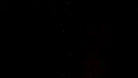 Tiny fire sparks lighting pitch dark black backdrop Video stock 201995135
