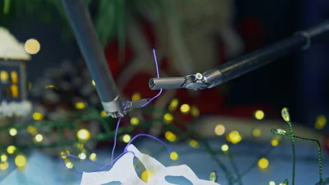 Tiny forceps of Da Vinci system tying a knot on a thread. Stock Footage 166315542