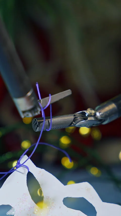 Tiny forceps of Da Vinci system tying a knot on a thread. Vidéo 275848032