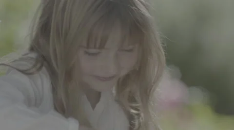 A tiny girl asks her mother questions as they sit on the back porch. Stock Footage 68363938