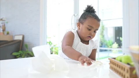 A tiny girl clean the table and floor after glass of milk spilled Video stock 292654952
