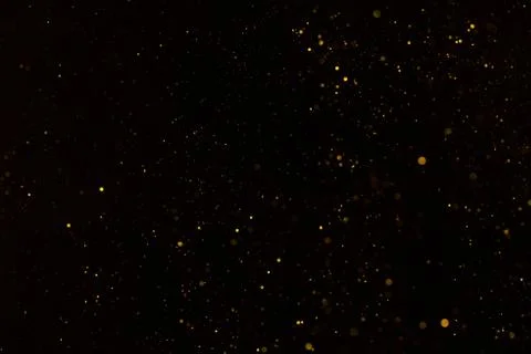 Tiny gold glitter falling on black background Foto stock