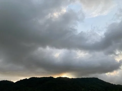 Tiny golden bright sunlight when sunset time with rainstorm cloud Stock Photos
