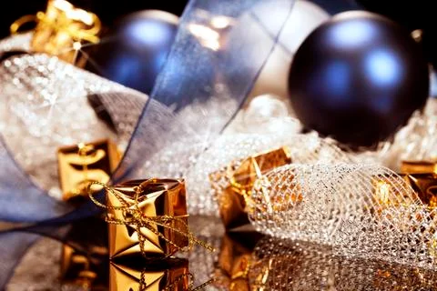 Tiny golden christmas present in front of christmas decoration Stock Photos