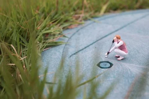 Tiny Golf Figurines Train Together On Textured Green Surface 스톡 사진