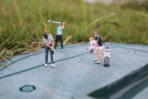 Tiny Golf Figurines Train Together On Textured Green Surface 스톡 사진