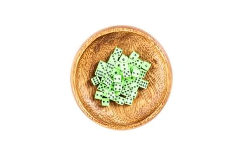 Tiny green neon dice pile in a wooden cup isolated over white Stock Photos