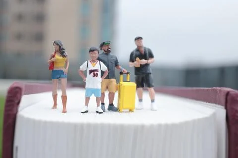 Tiny Group Stands Together Atop Thick Hardcover Book 写真素材