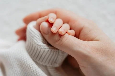 Tiny hand holding finger Stock Photos