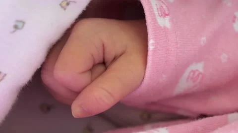 The tiny hands of the baby with the pink jacket.4K Stock Footage 134037015