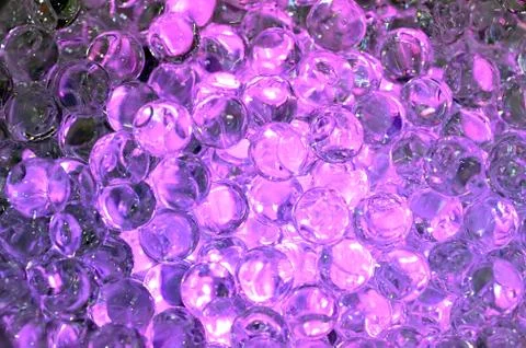 Tiny hard plastic beads balls in purple color background Foto stock