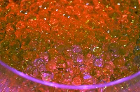 Tiny hard plastic beads balls in red color background Foto stock