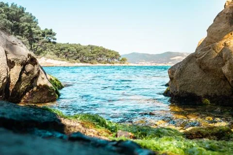 Tiny hidden beach surrounded by rocks on the shore of split, croatia. Green s Stock Photos