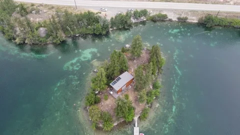 A tiny home built on a small secluded island near the shore of Pavilion Stock Footage 195104489