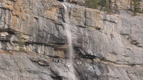 TINY HORSETAIL WATERFALL ON LARGE CLIFF Stock Footage 59073456