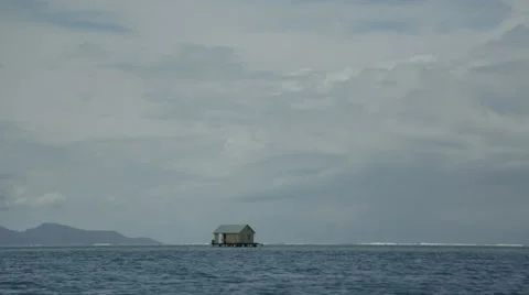 Tiny house stands by itself in the middle of the ocean Video stock 68100289