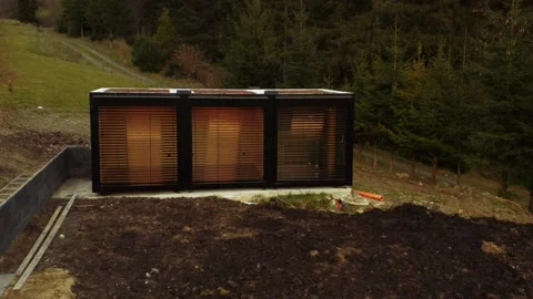 Tiny house transported and being built on site; low angle drone tracking Video stock 237979828