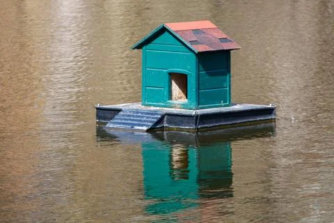 Tiny houseboat sits alone on quiet water Stock Photos