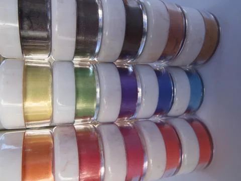 Tiny jars with multicoloured powders inside Stock Photos