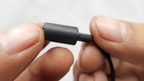 Tiny Lavalier Microphone Held by Hand on White Background in Macro Shot Stock Footage 310142944