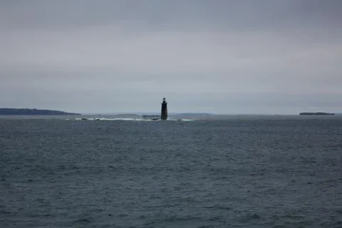 Tiny Lighthouse in Vast Ocean (landscape) Stock Photos