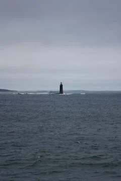 Tiny Lighthouse in Vast Ocean Stock Photos