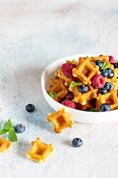Tiny (Mini) waffles waffles with berries in a white bowl Stock Photos