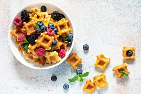 Tiny (Mini) waffles waffles with berries in a white bowl Stock Photos