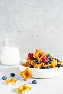 Tiny (Mini) waffles waffles with milk for breakfast with berries Foto stock