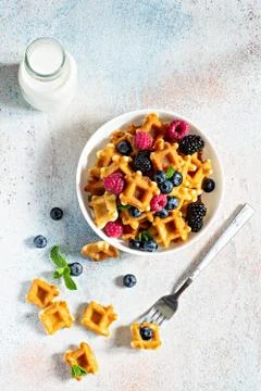 Tiny (Mini) waffles waffles with milk for breakfast with berries in a white bowl Stock Photos