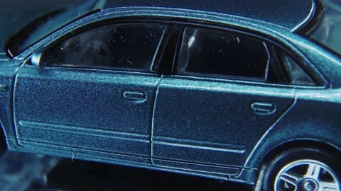 A tiny model metal sample car on a rotating stand with studio lights, Stock Footage 231941547