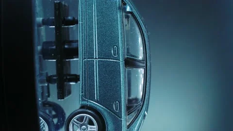 A tiny model metal sample car on a rotating stand with studio lights, Stock Footage 231942469