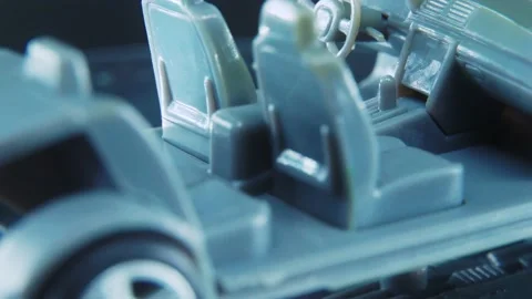 A tiny model metal sample skeleton of a car on a rotating stand with Stock Footage 231940608
