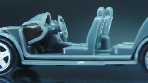 A tiny model metal sample skeleton of a car on a rotating stand with Stock Footage 231941226