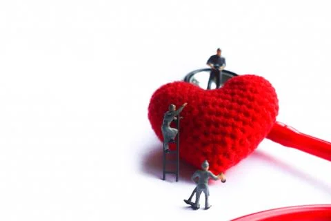 Tiny model take care red heart model near the red stetroscope on isolated bac Stock Photos