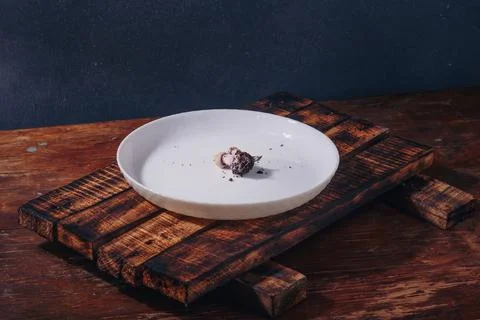Tiny mushroom with soil right on plate. Humanity using Earth resources Stock Photos