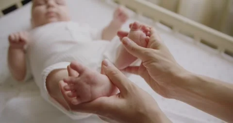 Tiny Newborn Babys feet on female Heart Shaped hands closeup. Stock Footage 323765231