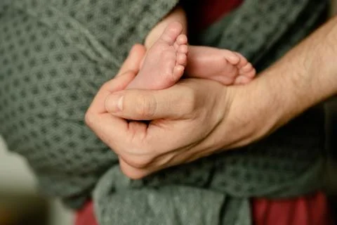 Tiny newborn feet in caring hands, trust and tenderness Stock-Fotos