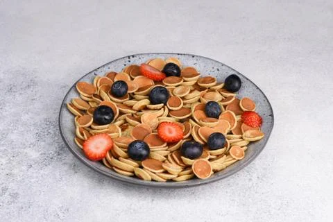 Tiny pancake cereal With Strawberries And Blueberries for breakfast. Stock Photos