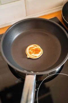 Tiny Pancake Frying in a Pan on the Stove Stock Photos