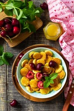 Tiny pancakes breakfast. Mini pancakes with cherries and honey. Foto stock