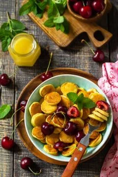 Tiny pancakes breakfast. Mini pancakes with cherries and honey. Foto stock