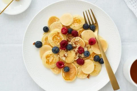 Tiny pancakes, small thin funny crumpet, children's food. Foto stock