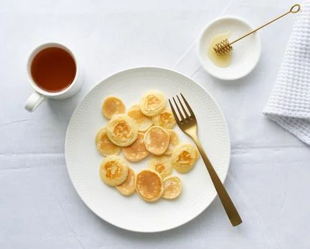 Tiny pancakes, small thin funny crumpet, children's food. Stock Photos