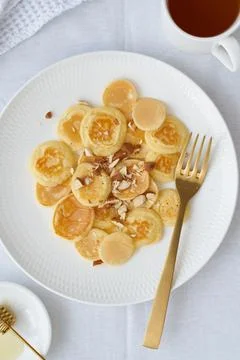 Tiny pancakes, small thin funny crumpet, children's food. Stock Photos