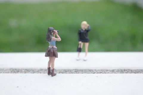 Tiny Photographer Captures Model Standing Across Textured Ledge Foto stock